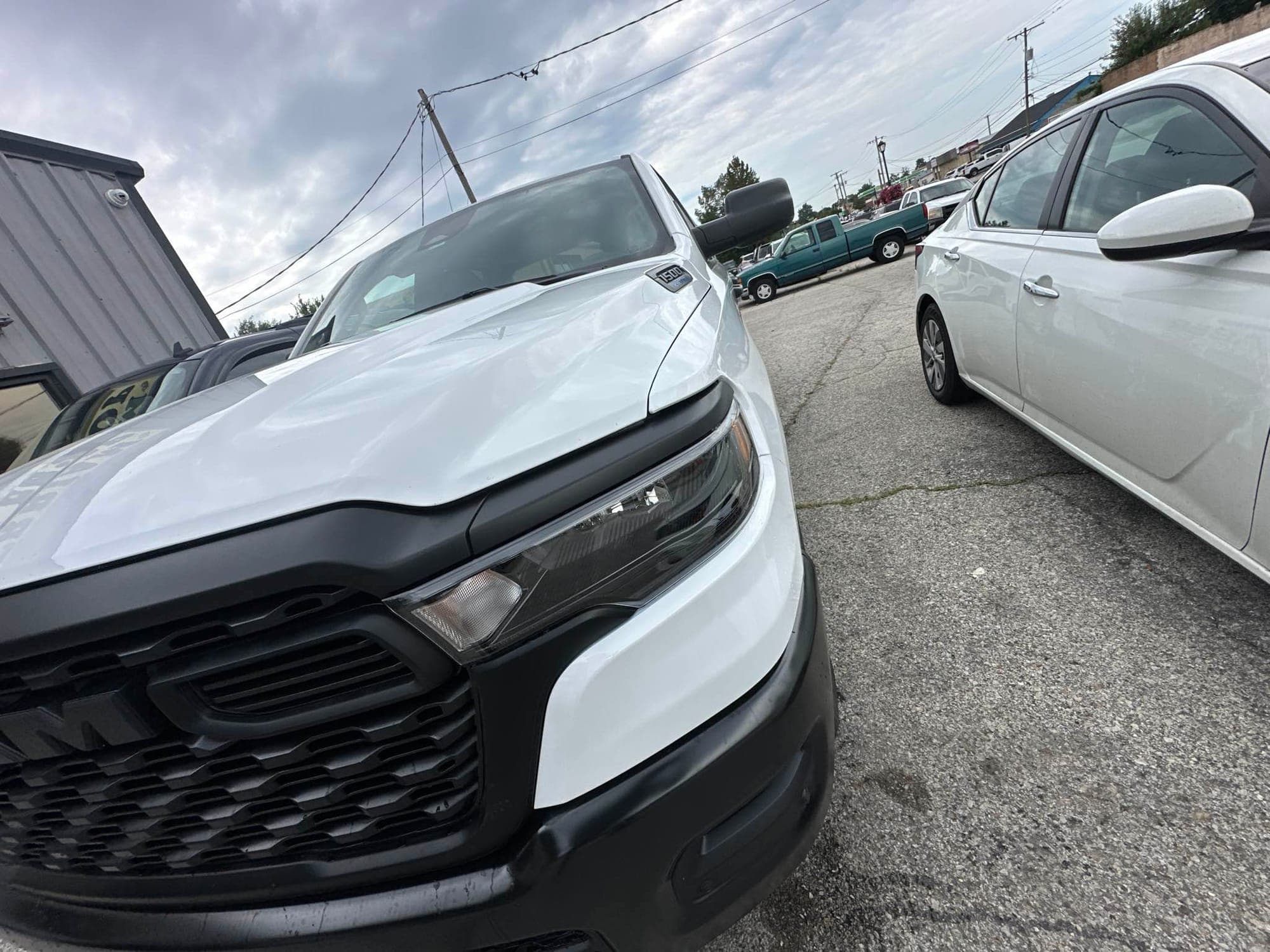 Pickup truck, front corner: after repair. The white pickup after repair with a new bumper and grille