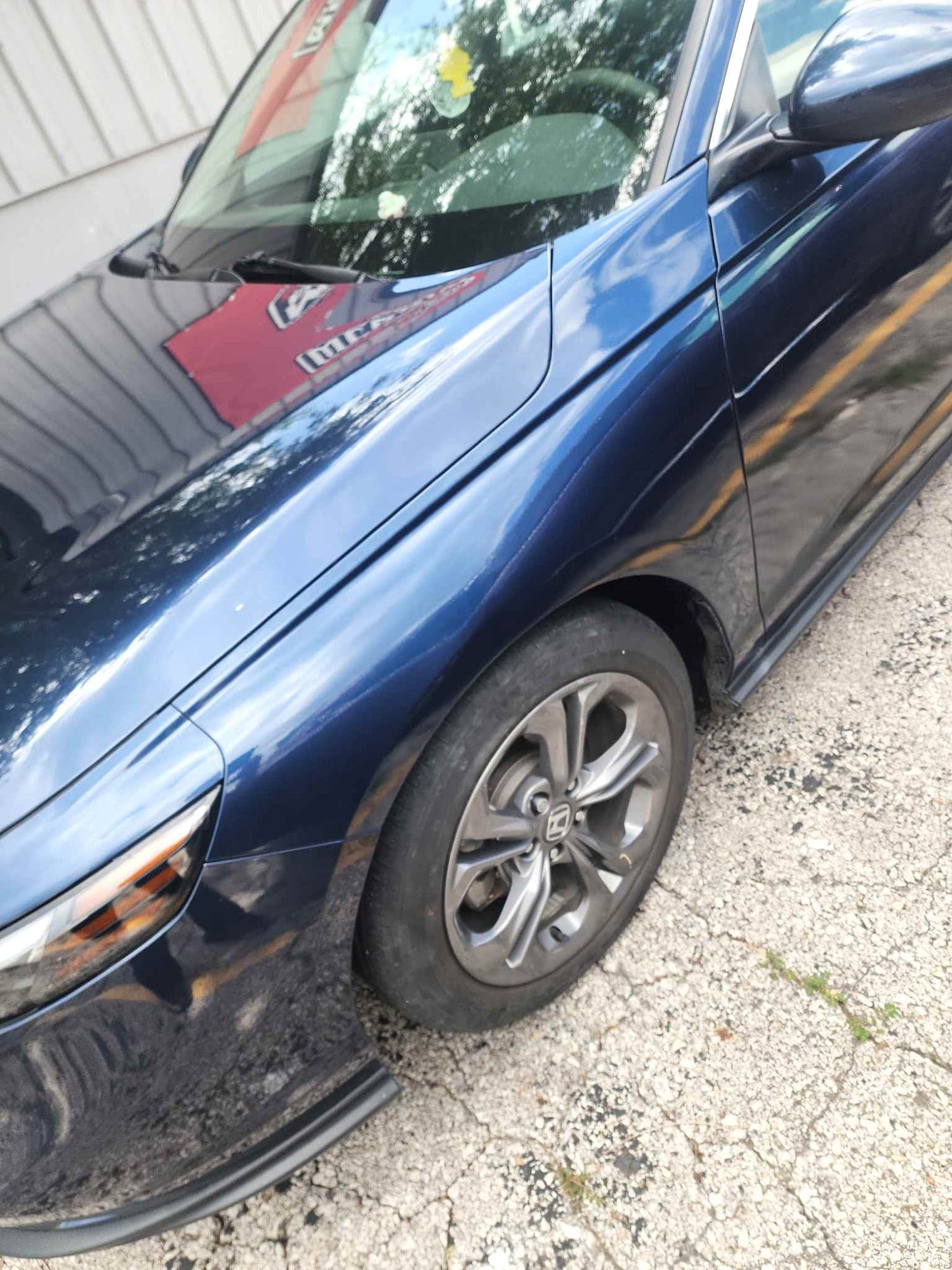 Sedan, fender: after repair. The dark blue sedan after the fender was repaired and refinished