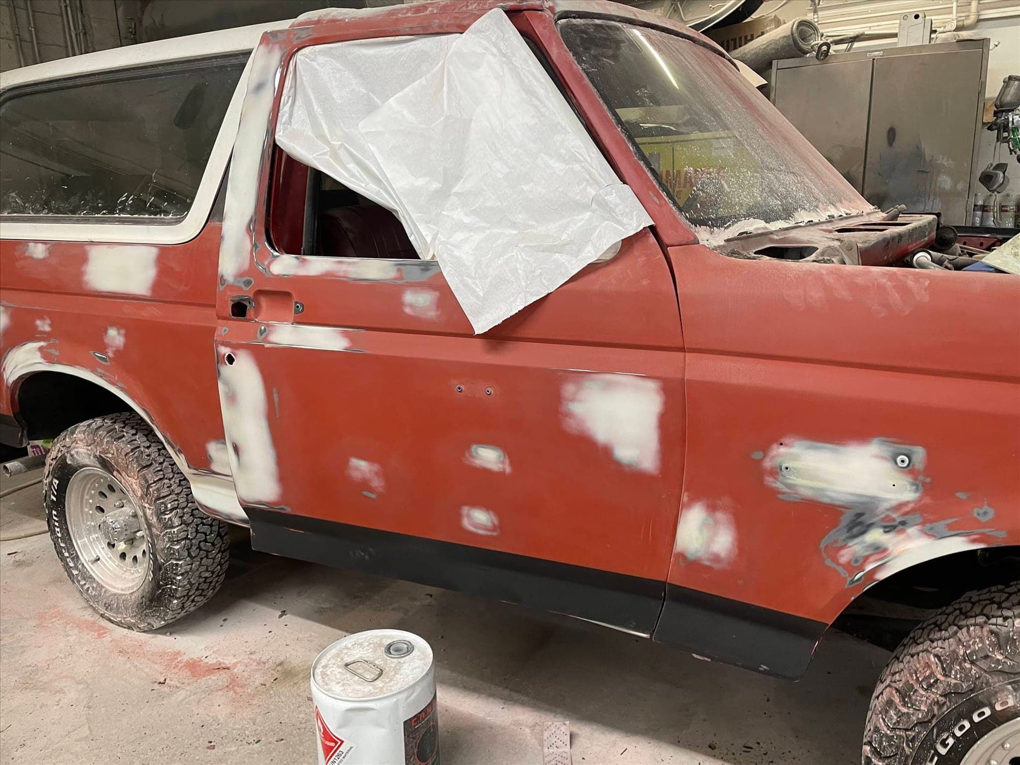 Ford Bronco restoration: before repair. The Bronco from the side, with body filler on the door and the rear window covered