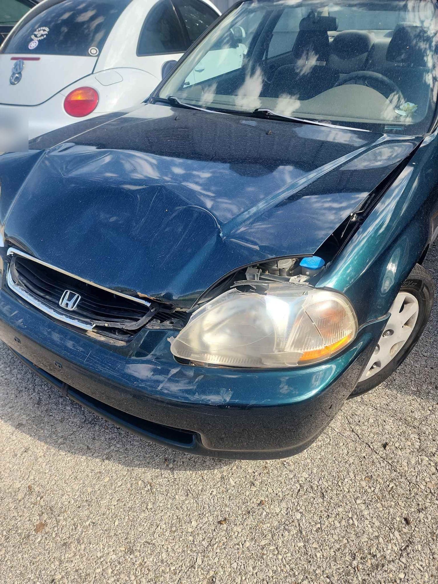 Honda Civic, front end: before repair. A Honda Civic with a crushed hood and broken headlight